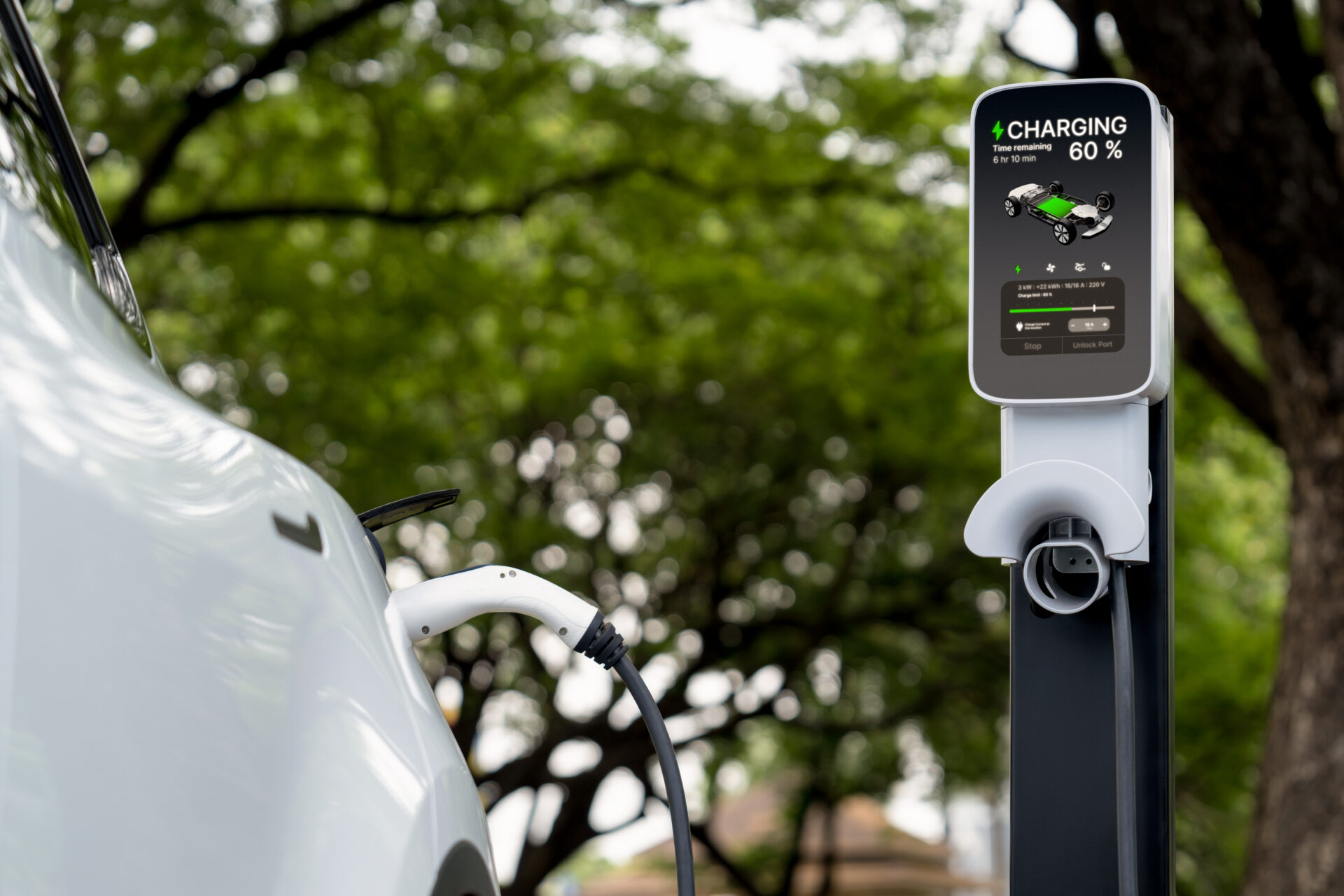 Electric car connected to an EV charging station in a green outdoor setting, showing 60% battery progress.