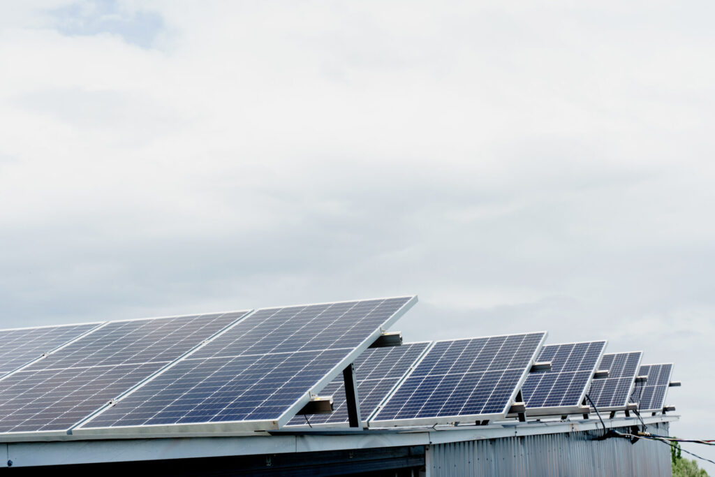 Rooftop solar panel installation on a commercial building producing eco-friendly electricity – a cost-effective renewable energy solution.