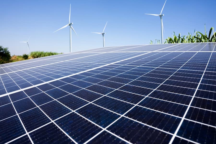Large solar panels and wind turbines showcasing renewable energy solutions