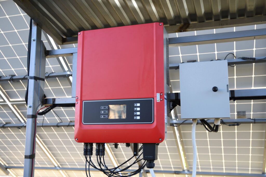 High-efficiency solar inverter installed beneath rooftop solar panels for optimal solar power generation.