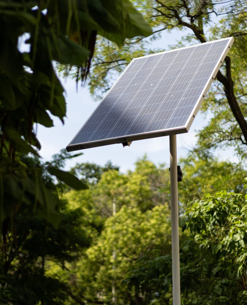 Off-grid solar panel system installed outdoors in a forested area, using renewable energy technology.